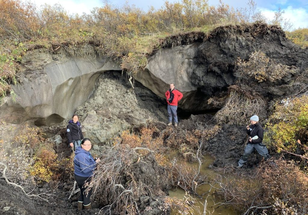 A research team from the Alfred Wegener Institute Helmholtz Centre for Polar and Marine Research posing in front of a small thaw slump near Kot